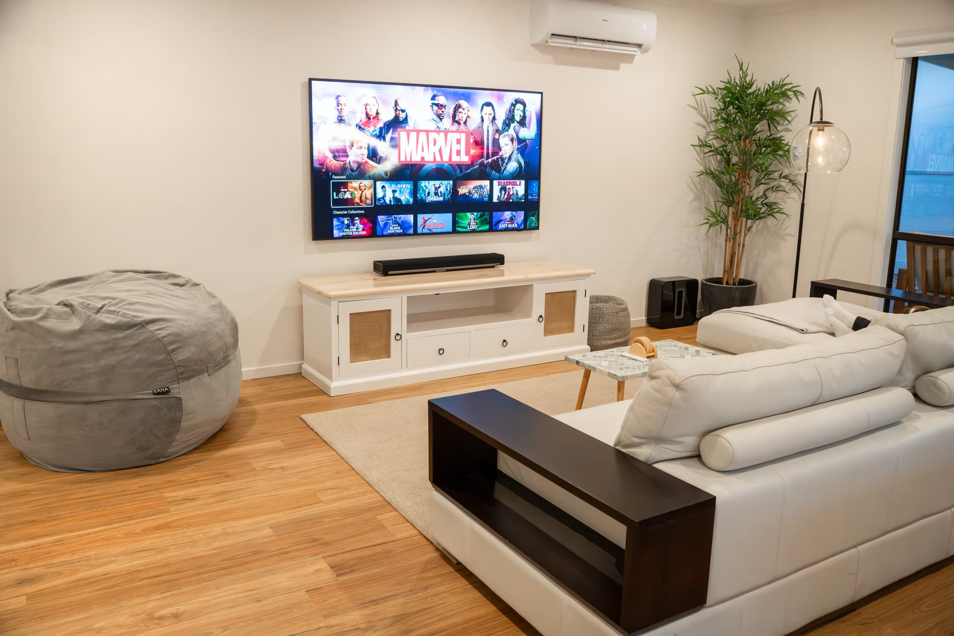 Home theatre with 75-inch smart TV and 5-seat couch at Big Isle Retreat