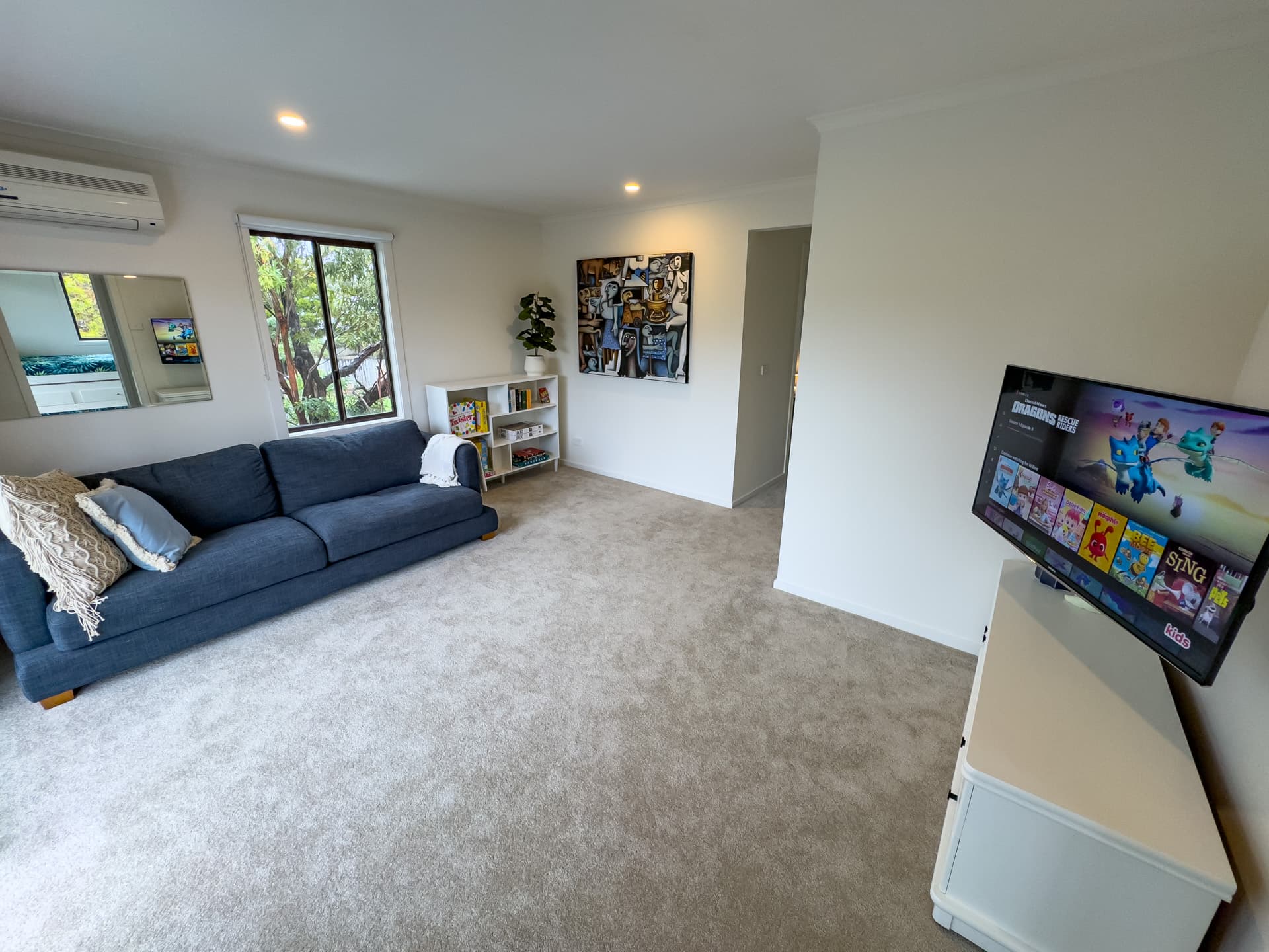Upstairs rumpus room with couch, TV and board games at Big Isle Retreat